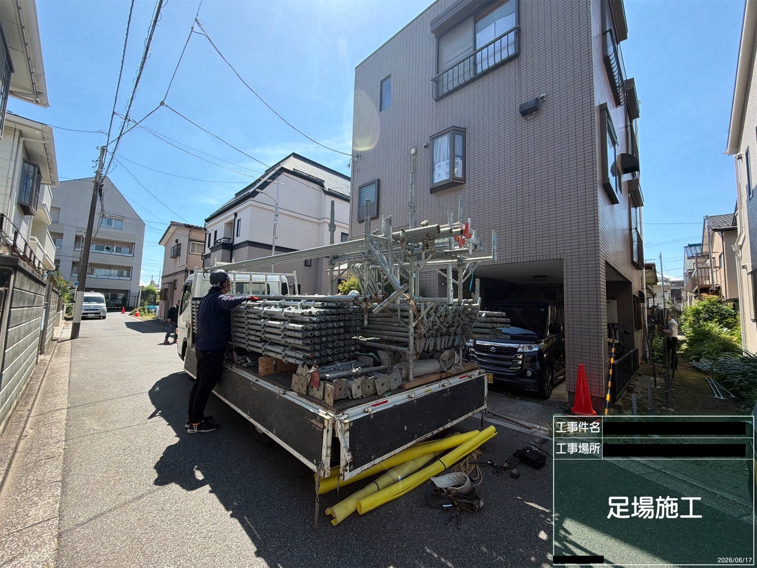 大規模修繕の初日、トラックで運び込まれた足場の鋼管などの資材